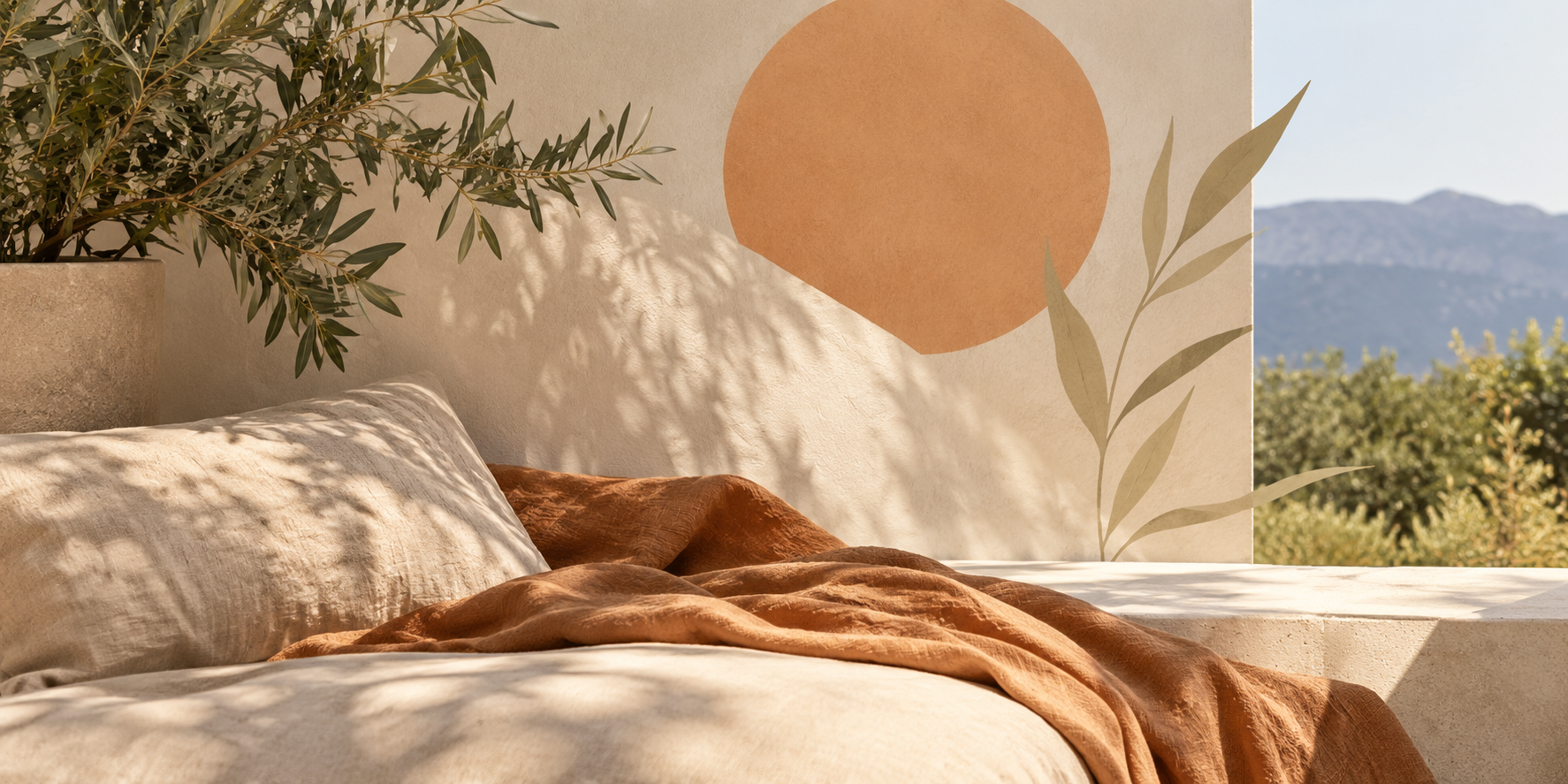 A warm sunlit resting space with linen, greenery and distant hills